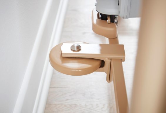 Ein beige-farbener Rollmechanismus an einer Stuhlbasis auf einem hellen Boden.