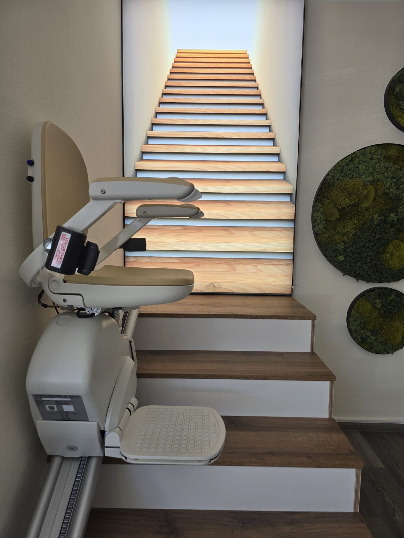 Treppenlift vor einer Treppe mit hölzernen Stufen und runden Wandornamenten.