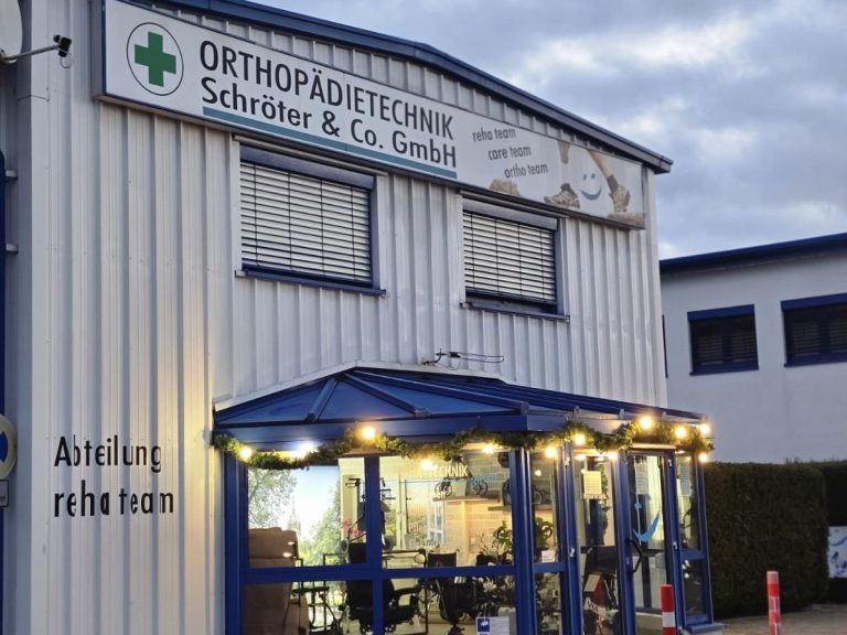 Fassade eines orthopädischen Geschäfts mit Außenbereich und beleuchtetem Eingang.