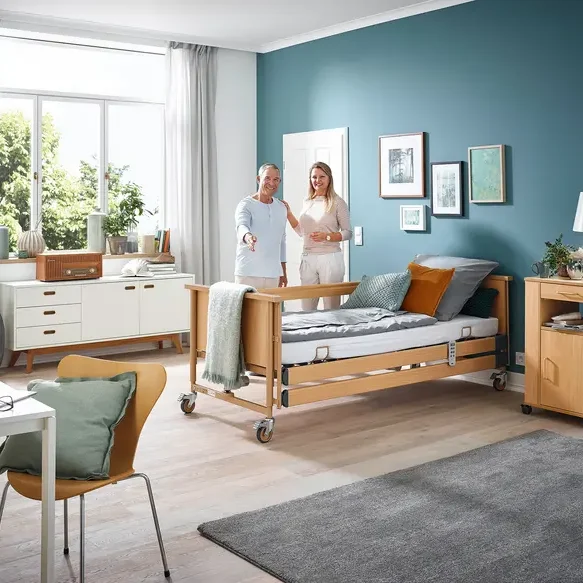Ein modernes Schlafzimmer mit einem Pflegebett und freundlichen Personen.